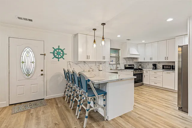 a kitchen with granite countertop a white refrigerator oven a sink and cabinets