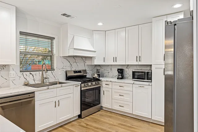 a kitchen with white cabinets sink and white appliances
