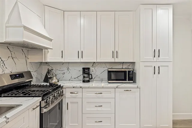 a kitchen with white cabinets and appliances