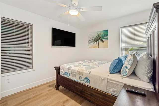 a bed sitting in a bedroom next to a window with a flat screen tv and a fireplace