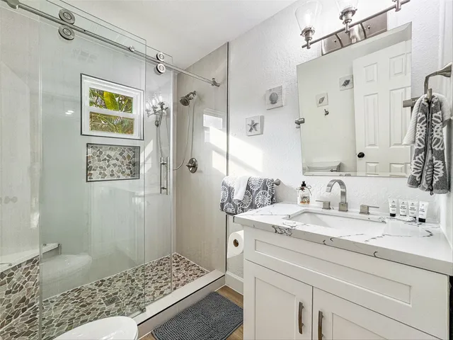 a bathroom with a sink a mirror and a shower