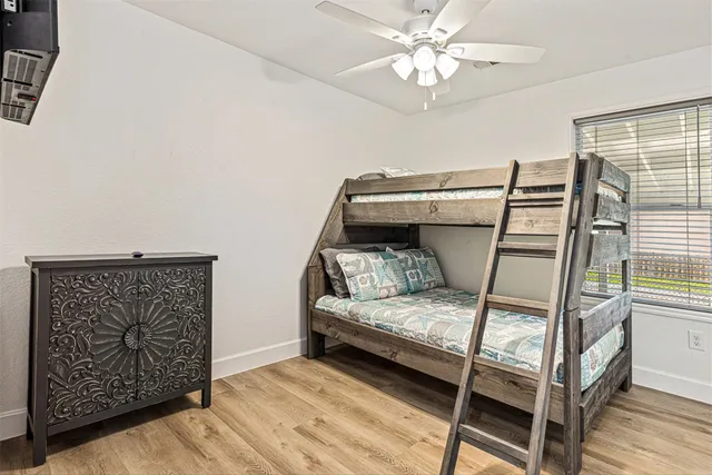 a bedroom with a bed and a ceiling fan