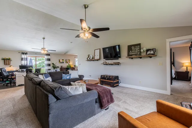 a living room with furniture a ceiling fan and a window