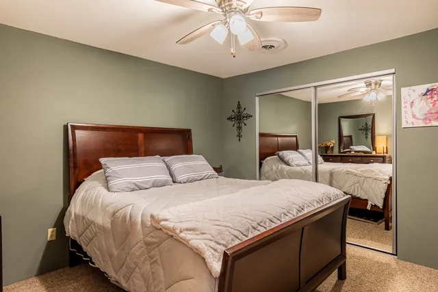 a bedroom with a large bed and a chandelier
