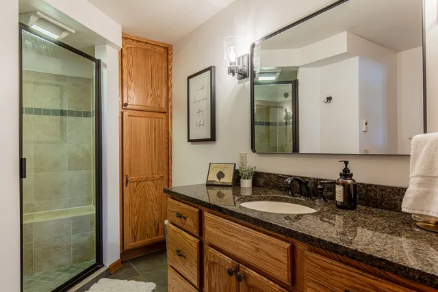 a bathroom with a granite countertop sink and a mirror