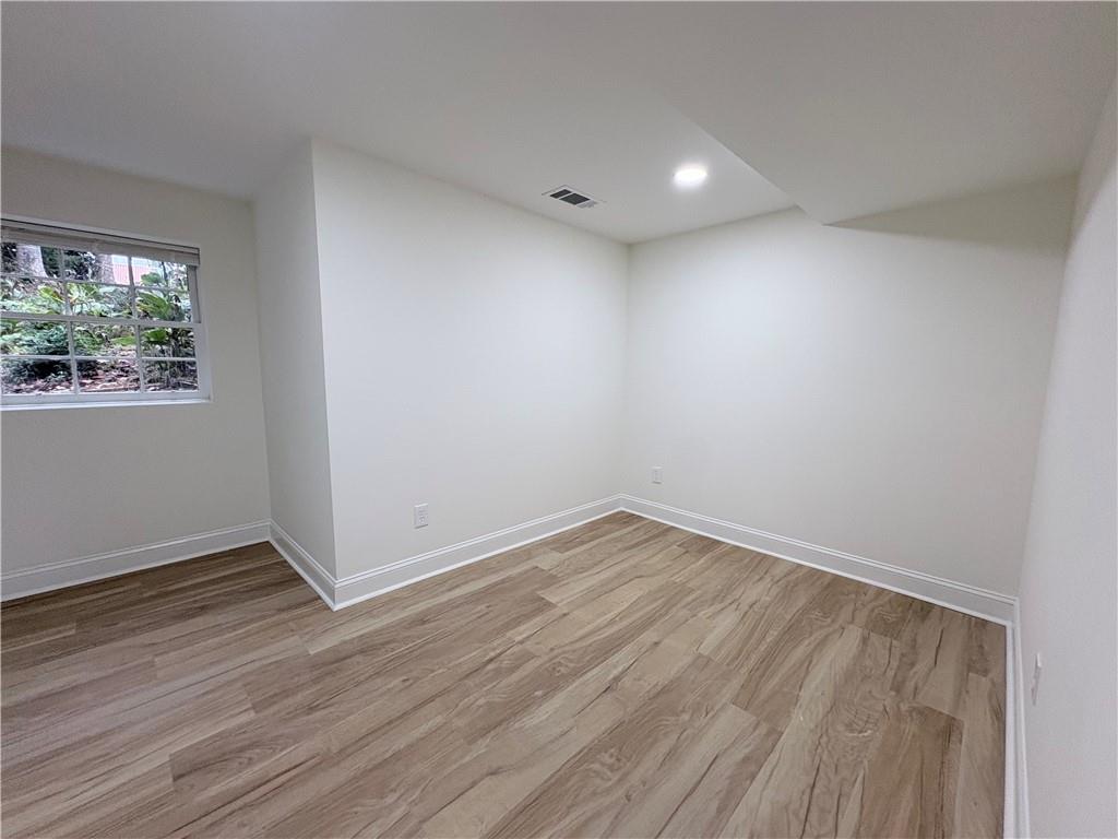 1110 Upper Hembree Road Roswell, GA 30076 - Photo 37 of 51 a view of an empty room with wooden floor and a window