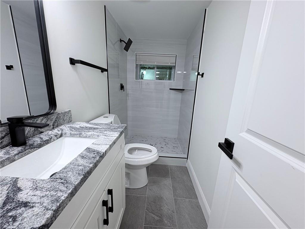 1110 Upper Hembree Road Roswell, GA 30076 - Photo 38 of 51 a bathroom with a granite countertop sink a toilet and a mirror