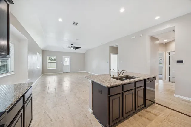 a view of a kitchen island a sink and dishwasher with wooden floor