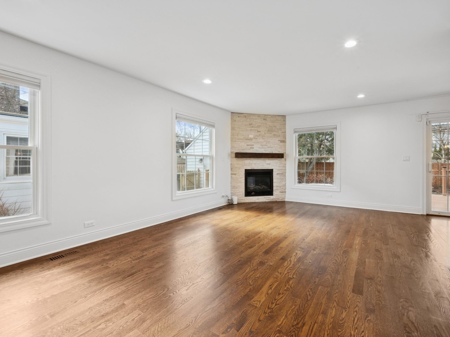 716 Indian Road Glenview, IL 60025 - Photo 5 of 32 an empty room with wooden floor fireplace and windows