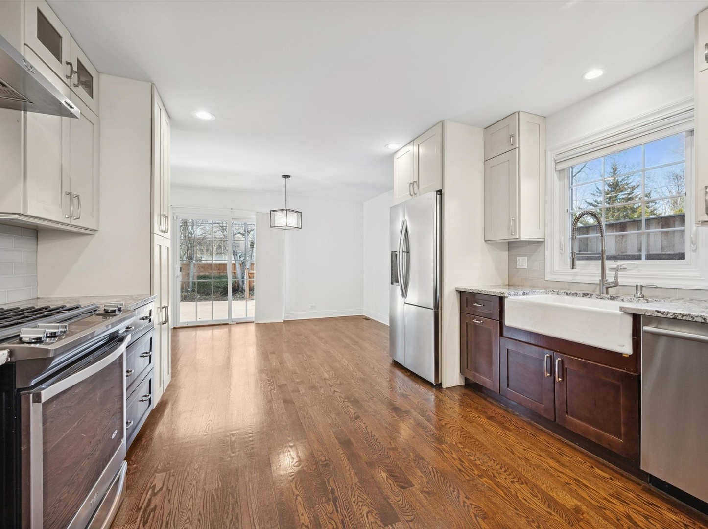 716 Indian Road Glenview, IL 60025 - Photo 9 of 32 a large kitchen with stainless steel appliances granite countertop a stove a sink dishwasher and a refrigerator with wooden floor