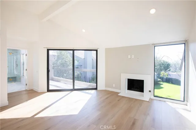 a view of an empty room with glass door and balcony