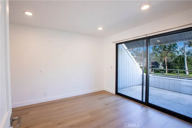 an empty room with wooden floor and a window
