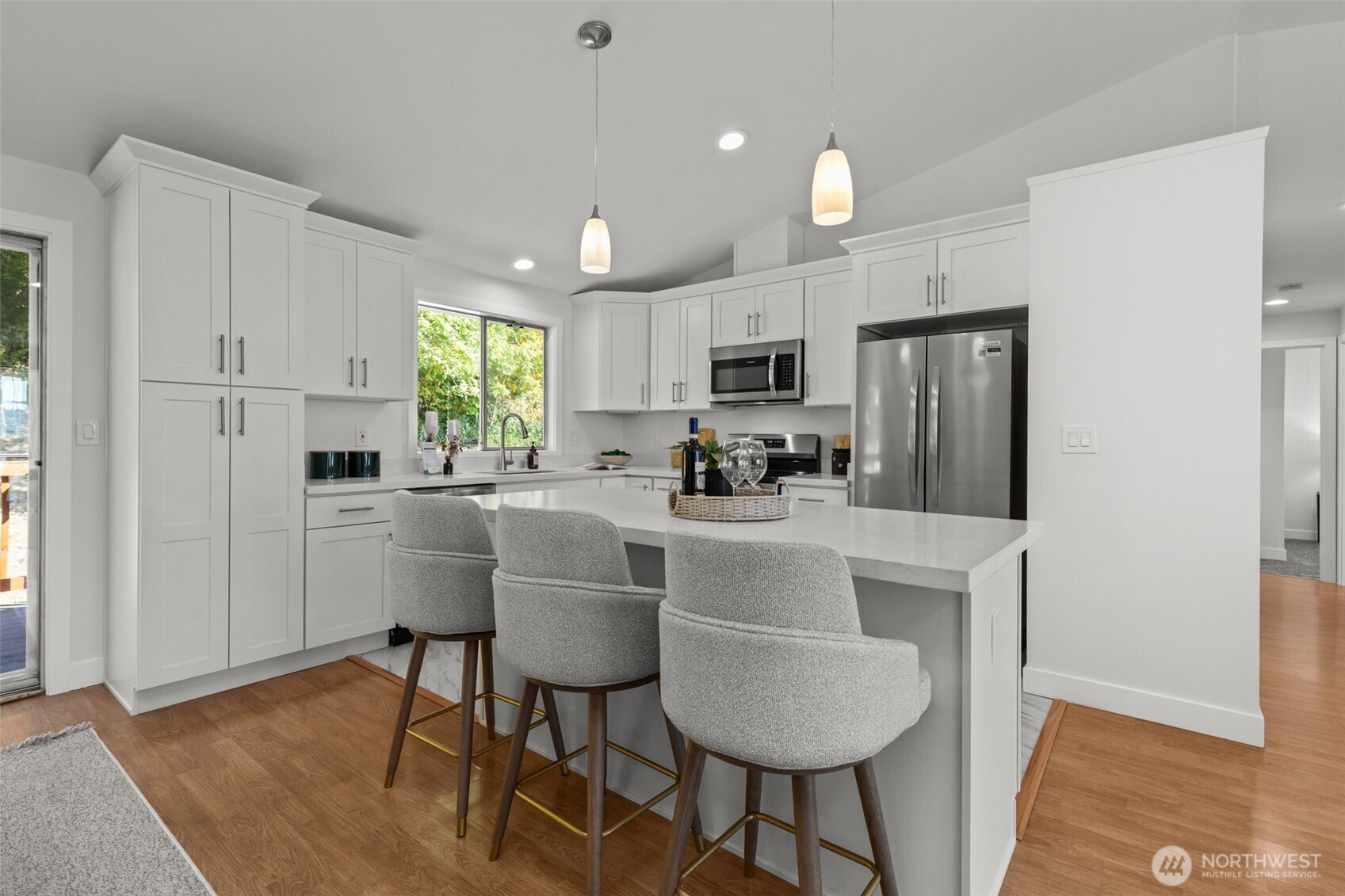 11822 56th Place South Seattle, WA 98178 - Photo 12 of 39 a kitchen with kitchen island granite countertop a refrigerator a stove a dining table and chairs with wooden floor