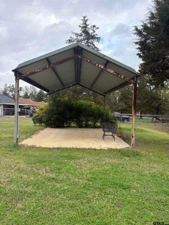 a view of a patio with a table and chairs under an umbrella