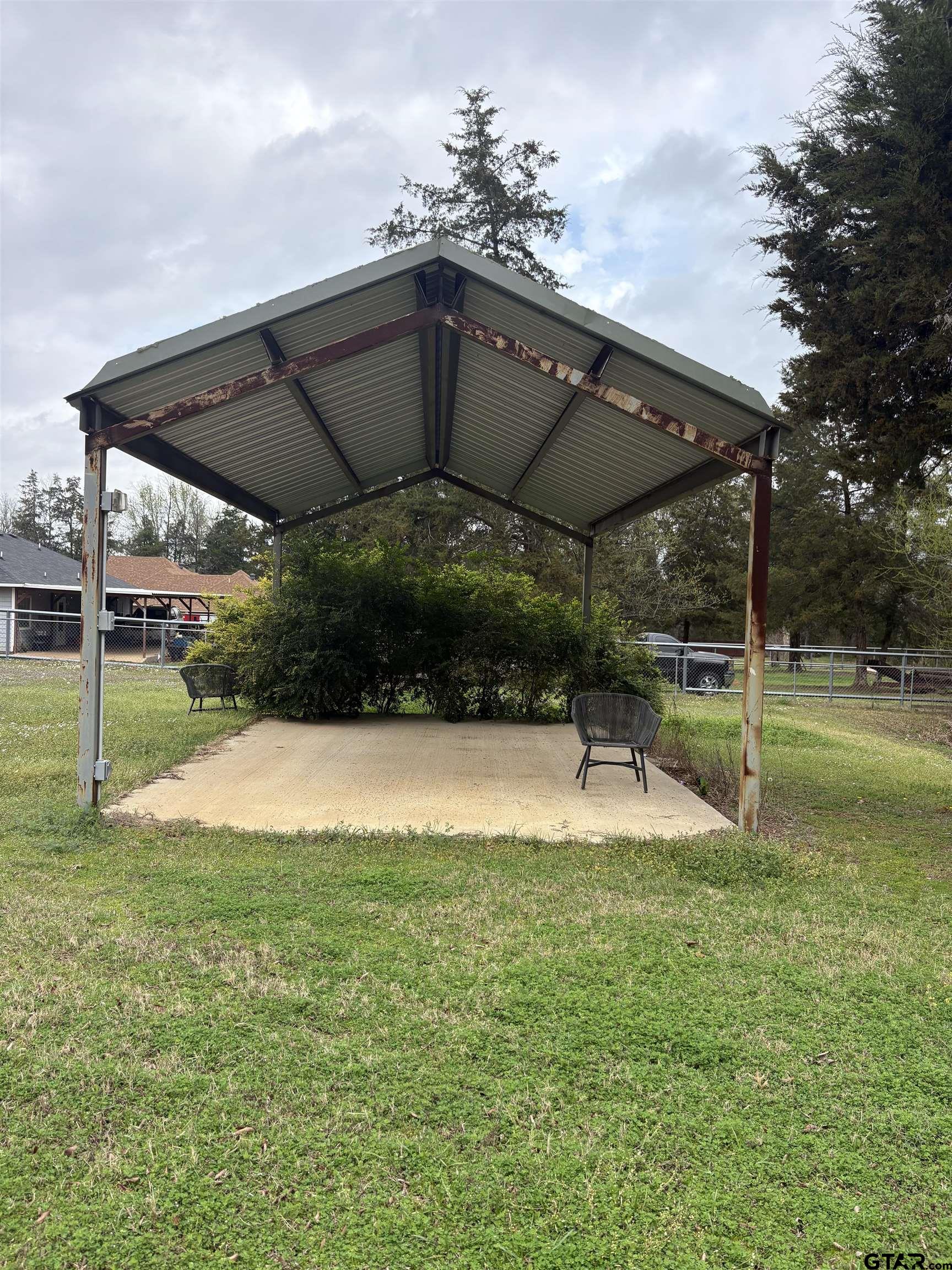 a view of a patio with a table and chairs under an umbrella