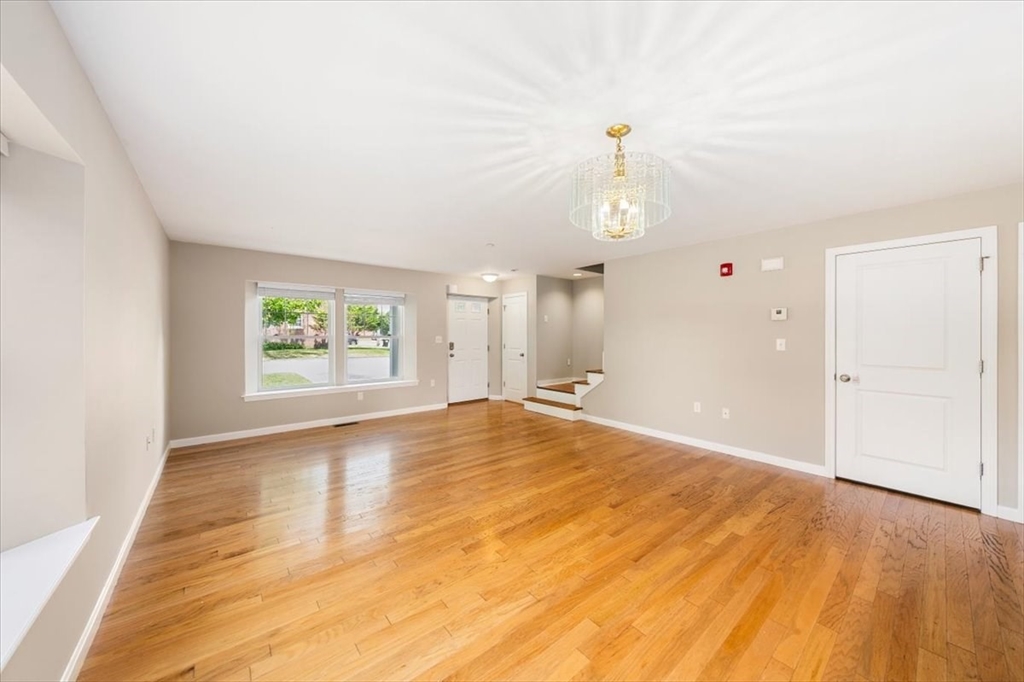 6 Bates Street, Unit A Devens, MA 01434 - Photo 11 of 41 an empty room with wooden floor ceiling fan and windows