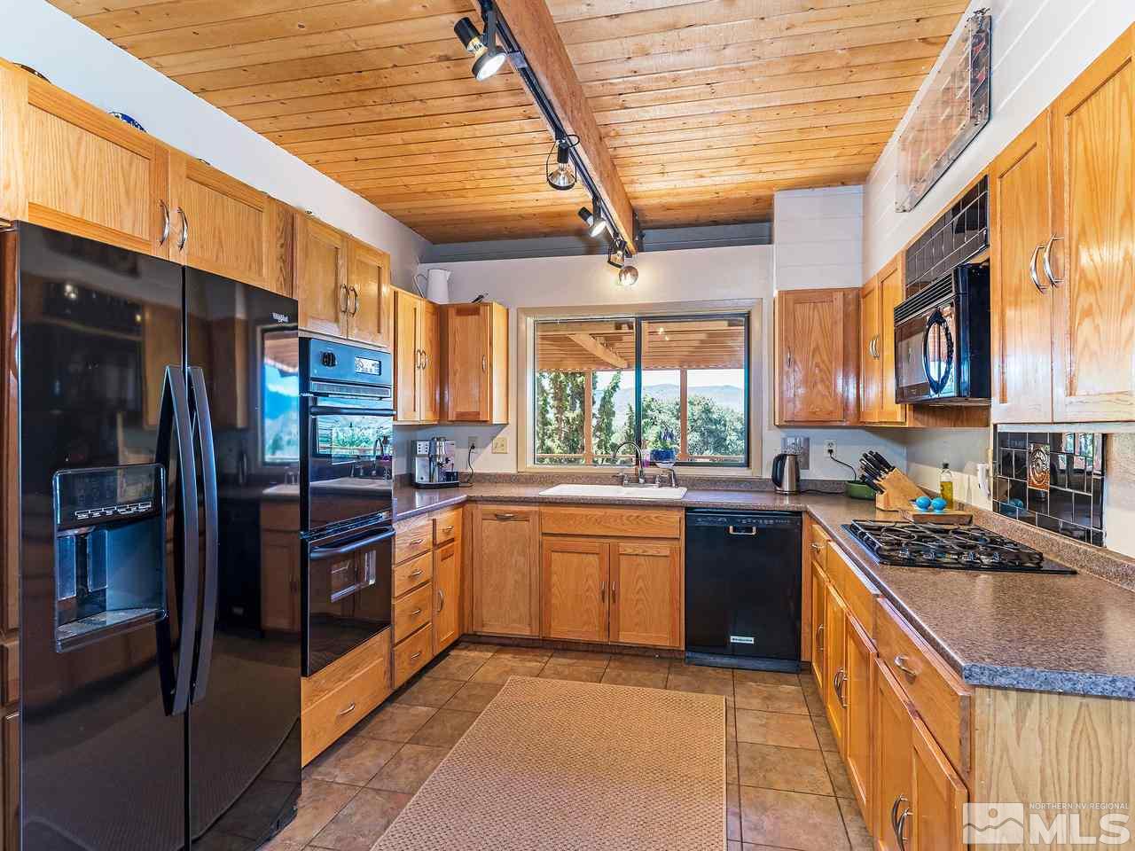 14748 Pine Knolls Lane Reno, NV 89521 - Photo 2 of 33 a kitchen with stainless steel appliances granite countertop a stove a sink and a refrigerator