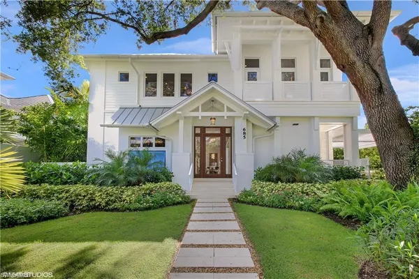 a front view of a house with a garden and plants