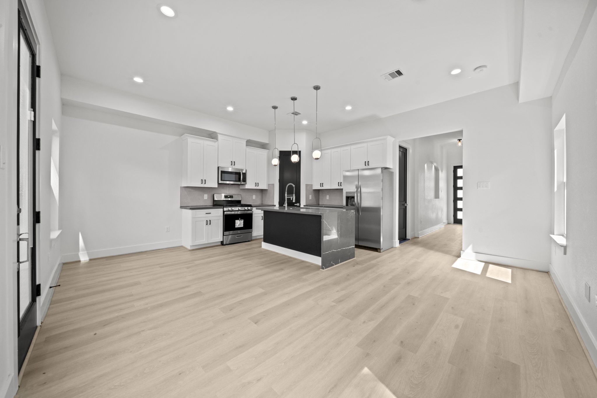 4930 Chennault Road, Unit A Houston, TX 77033 - Photo 6 of 16 a view of kitchen with stainless steel appliances kitchen island wooden floor and window