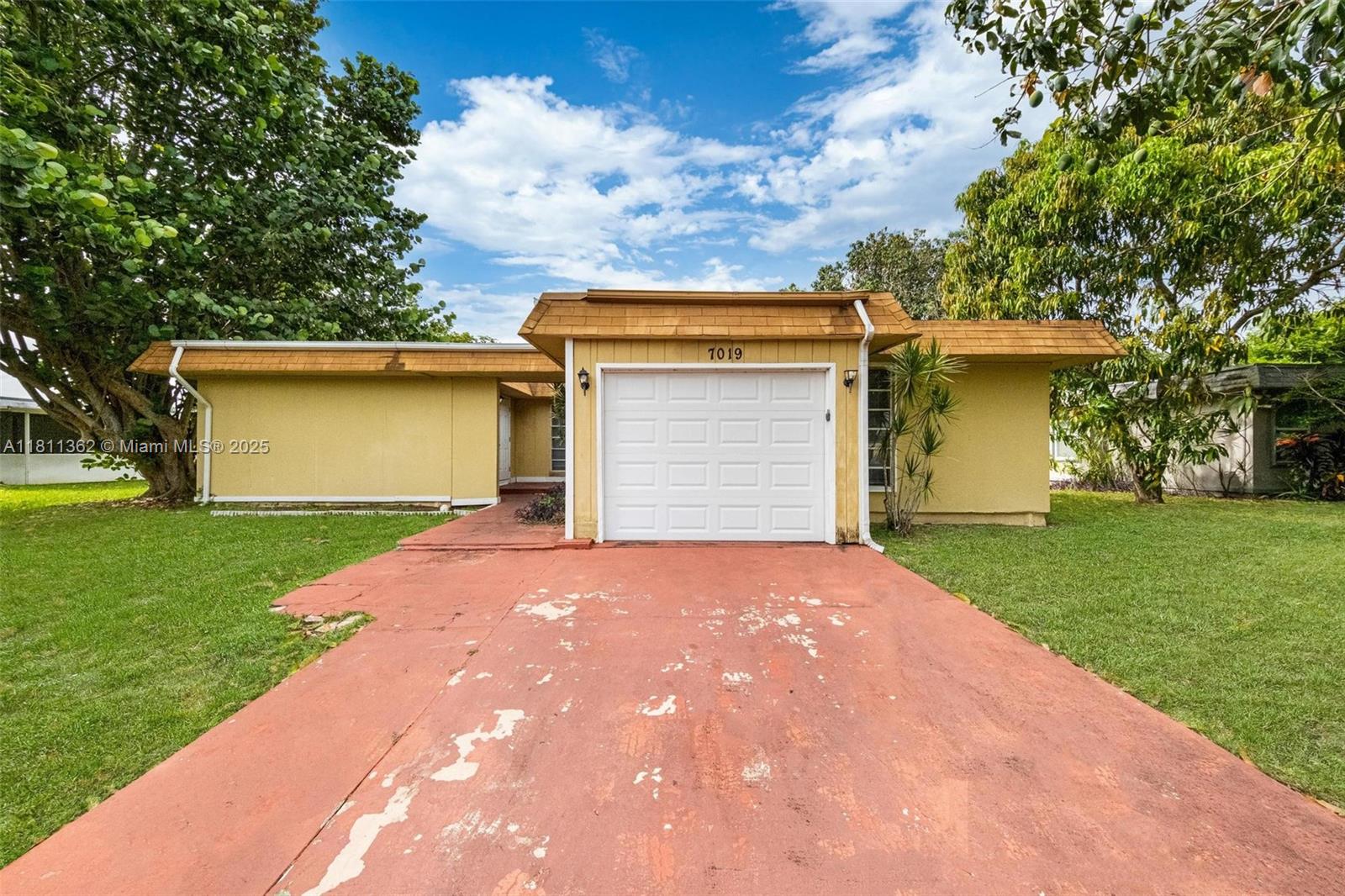 7019 Northwest 63rd Street Tamarac, FL 33321 - Photo 1 of 33 a front view of house with a garden