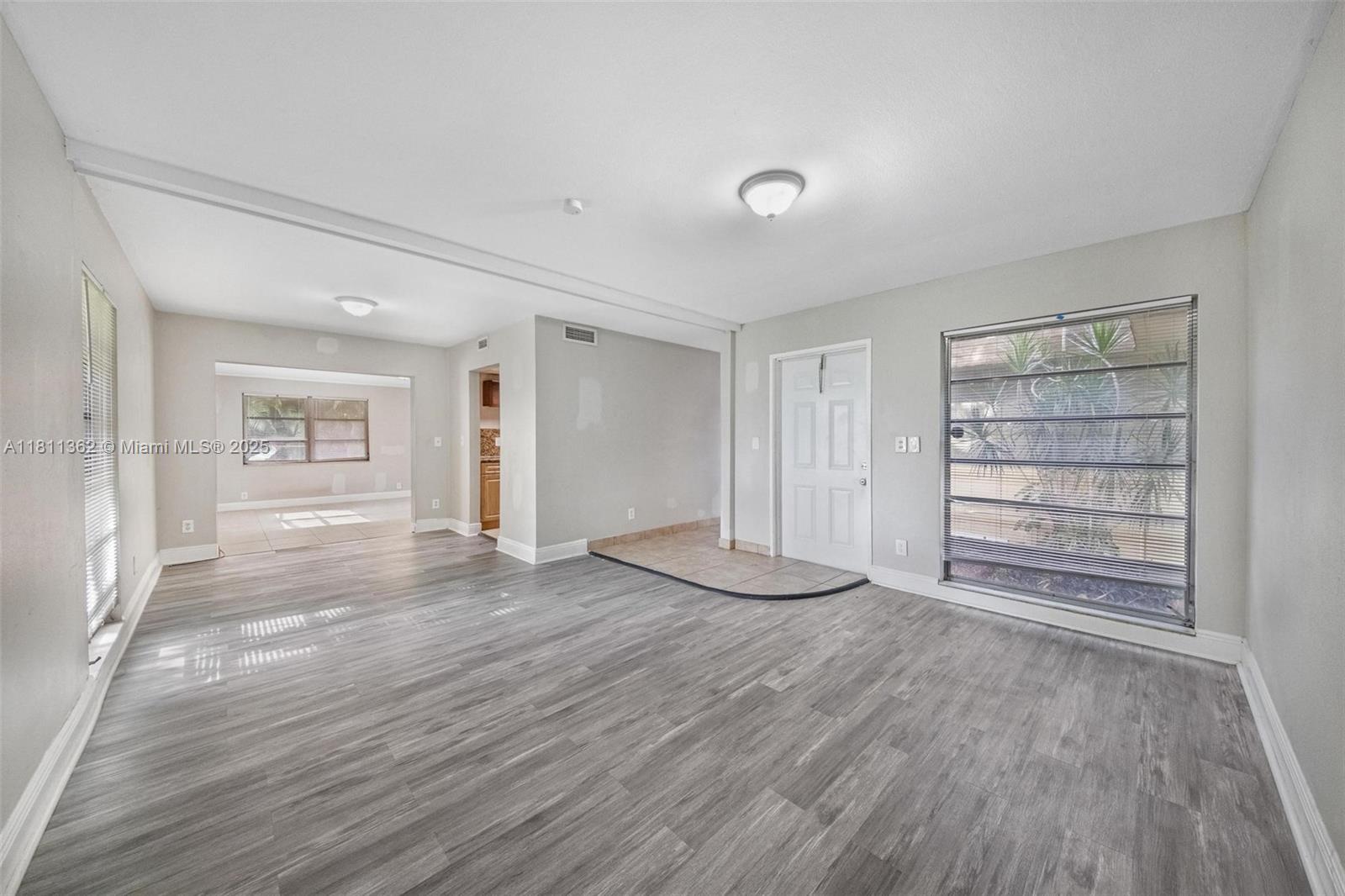 7019 Northwest 63rd Street Tamarac, FL 33321 - Photo 15 of 33 a view of an empty room with wooden floor and a window