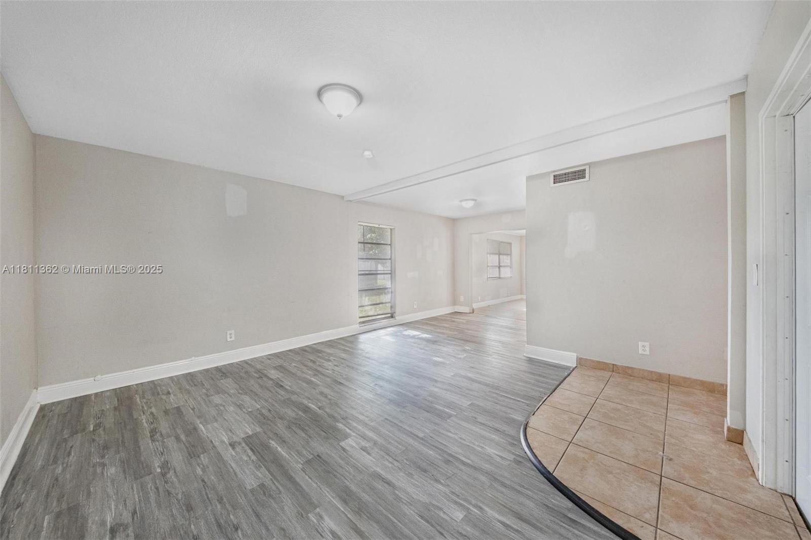 7019 Northwest 63rd Street Tamarac, FL 33321 - Photo 16 of 33 an empty room with wooden floor and windows