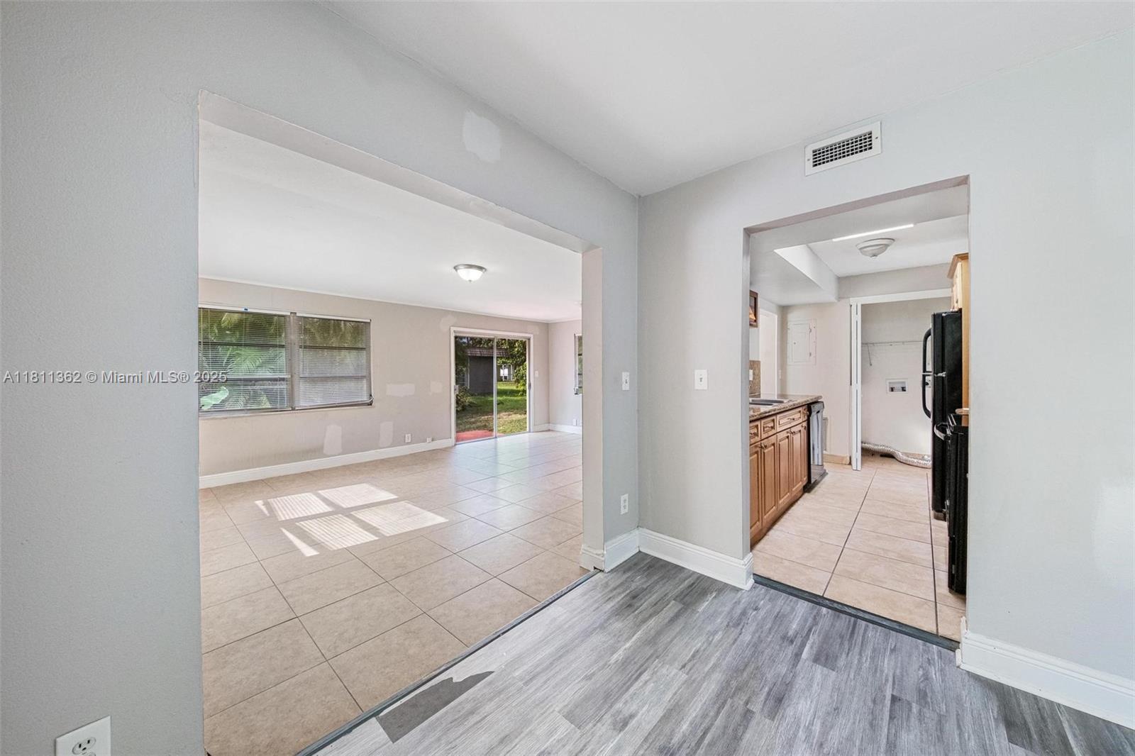 7019 Northwest 63rd Street Tamarac, FL 33321 - Photo 18 of 33 a view of a hallway with wooden floor and a living room