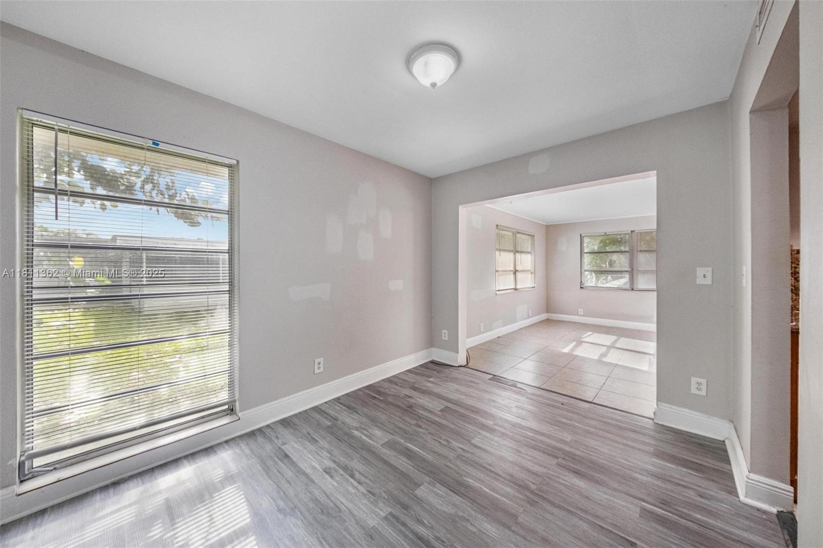 7019 Northwest 63rd Street Tamarac, FL 33321 - Photo 19 of 33 an empty room with wooden floor and windows
