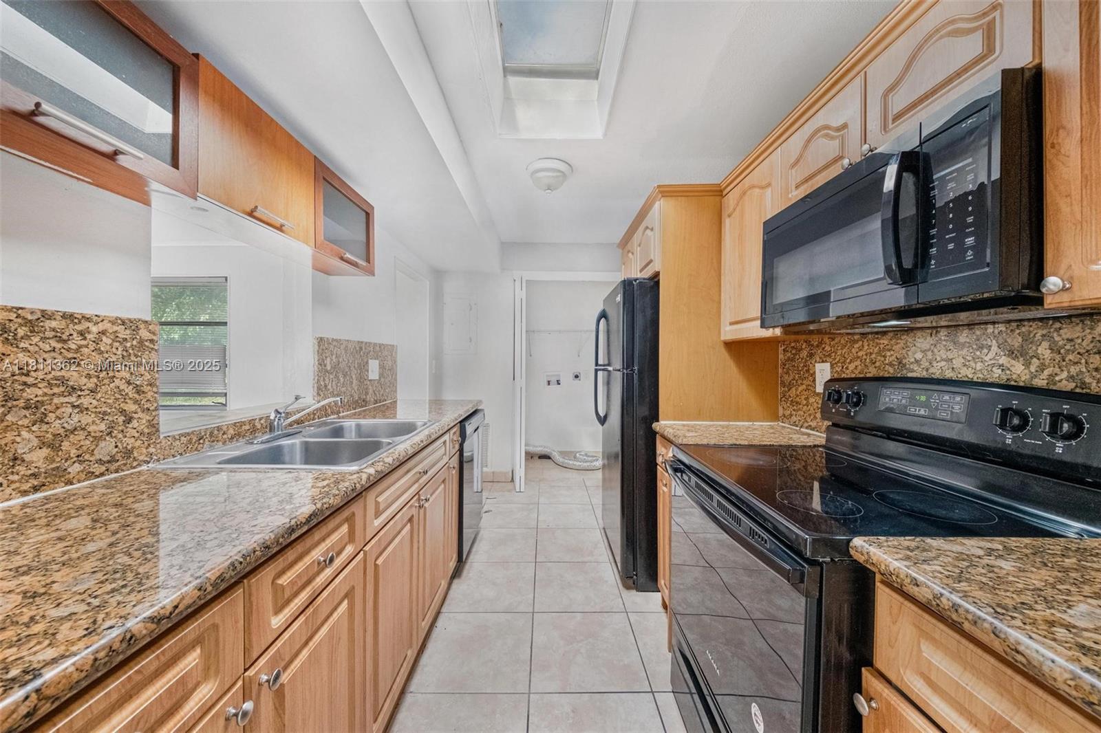 7019 Northwest 63rd Street Tamarac, FL 33321 - Photo 20 of 33 a kitchen with a sink stove and cabinets