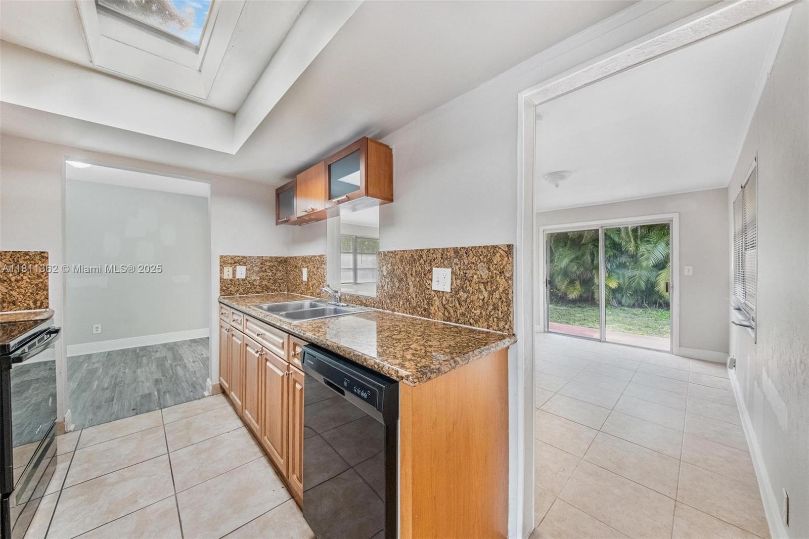 7019 Northwest 63rd Street Tamarac, FL 33321 - Photo 22 of 33 a kitchen with stainless steel appliances granite countertop a stove a sink and a refrigerator