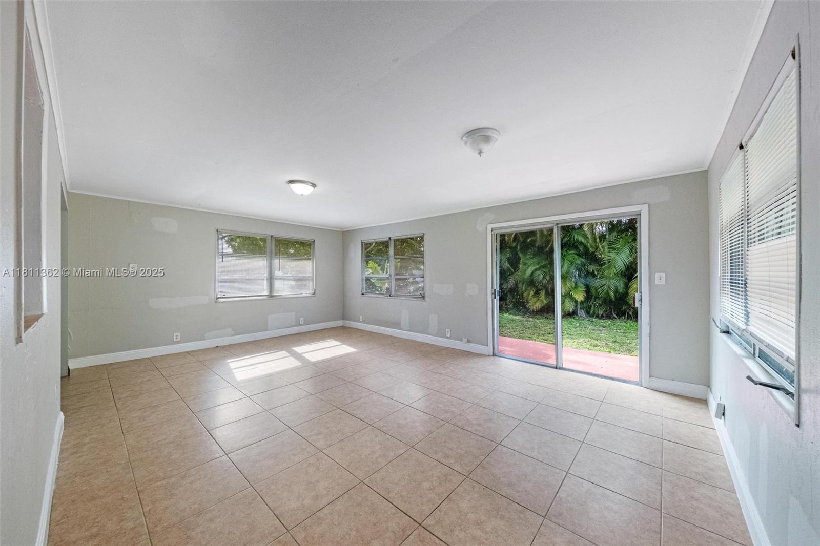 7019 Northwest 63rd Street Tamarac, FL 33321 - Photo 23 of 33 a view of an empty room with windows and chandelier