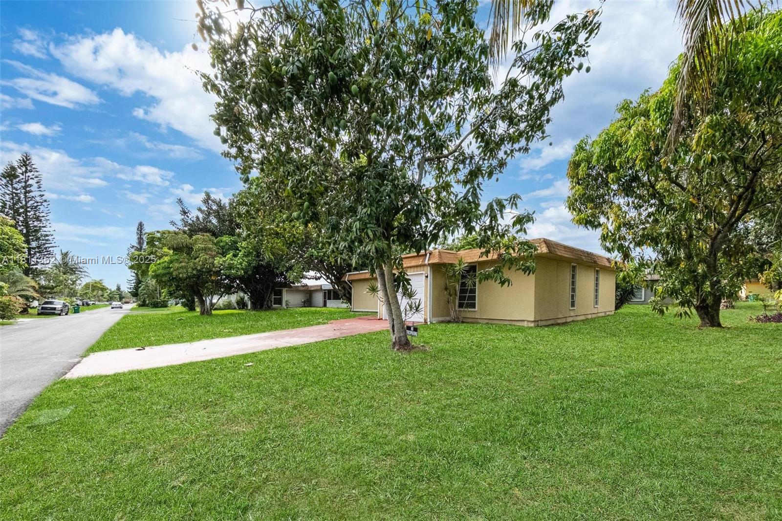 7019 Northwest 63rd Street Tamarac, FL 33321 - Photo 25 of 33 a white house with a big yard and large trees