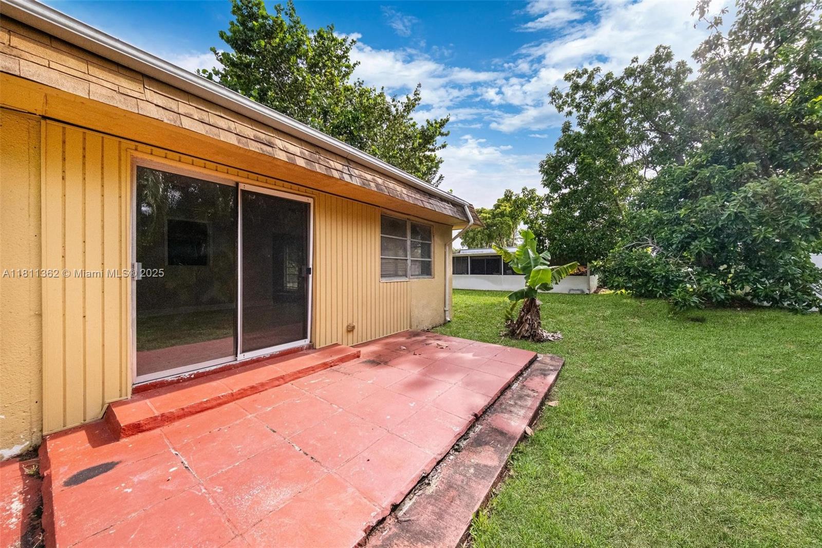 7019 Northwest 63rd Street Tamarac, FL 33321 - Photo 29 of 33 a backyard of a house with plants and large tree