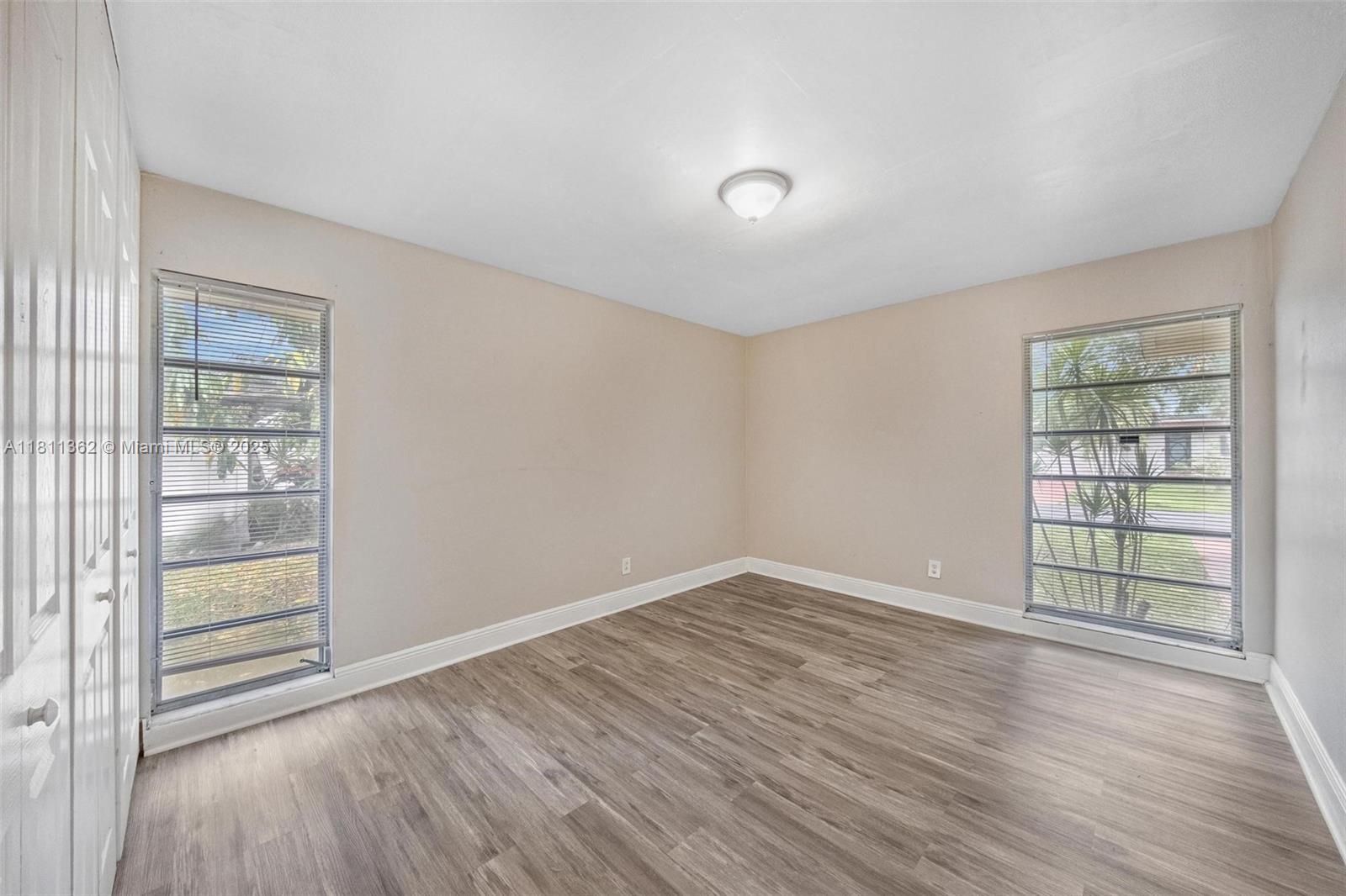7019 Northwest 63rd Street Tamarac, FL 33321 - Photo 3 of 33 an empty room with wooden floor and windows