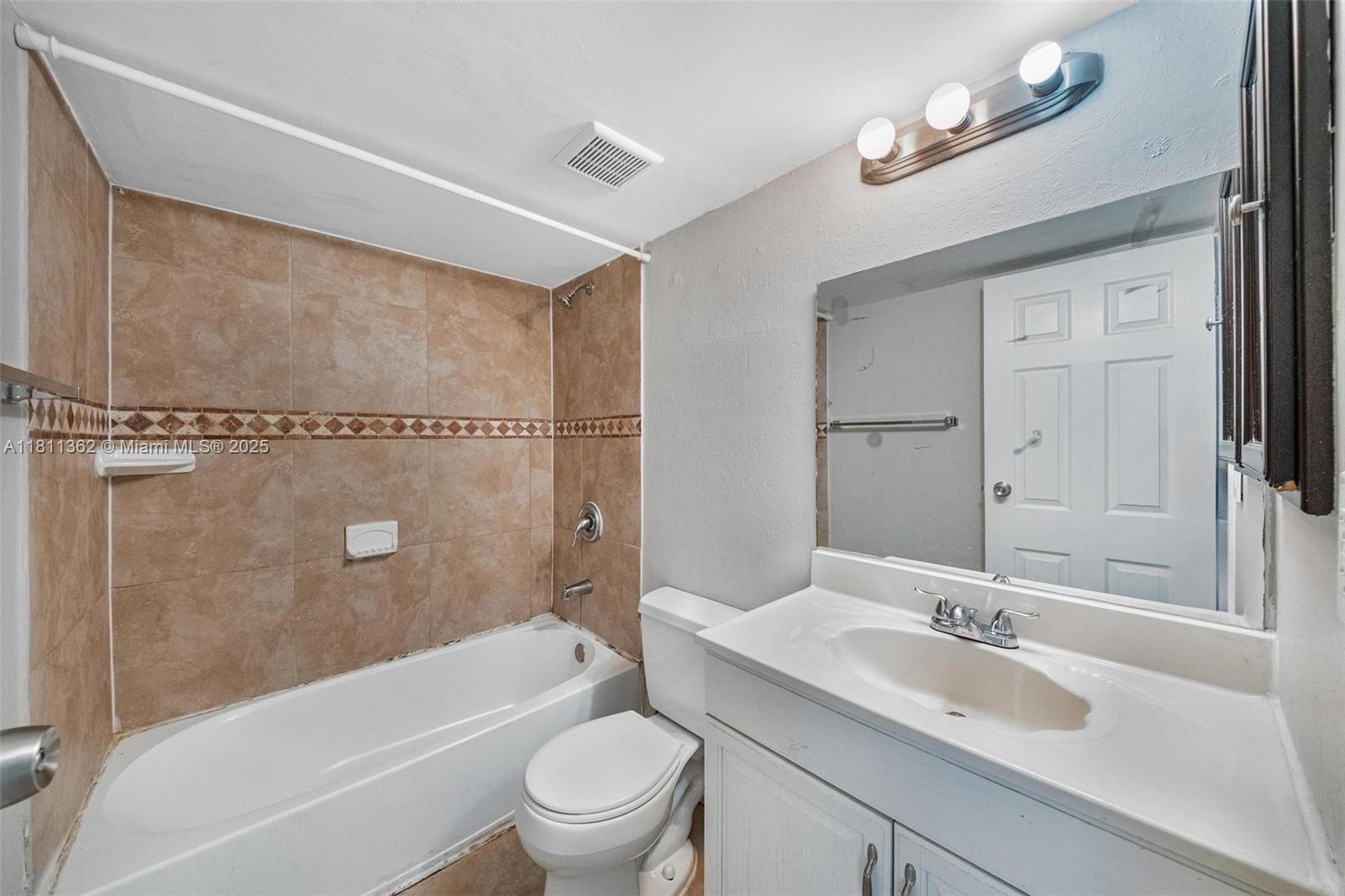 7019 Northwest 63rd Street Tamarac, FL 33321 - Photo 7 of 33 a bathroom with a sink mirror toilet and bathtub