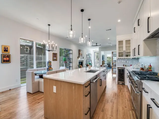 a kitchen with stainless steel appliances granite countertop a sink a stove and a wooden floors