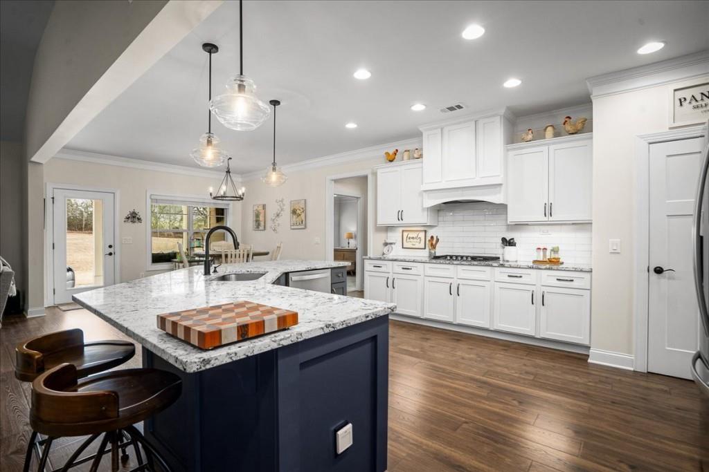 641 Haven Way Monroe, GA 30655 - Photo 5 of 55 a kitchen with granite countertop kitchen island white cabinets and refrigerator