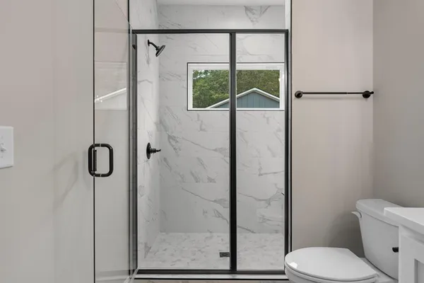 a bathroom with a toilet and a shower