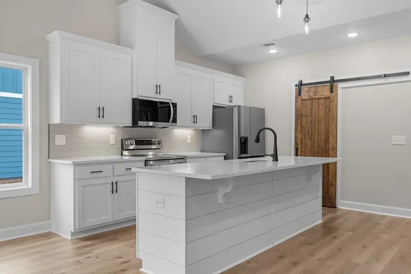 a kitchen with appliances a sink and a microwave