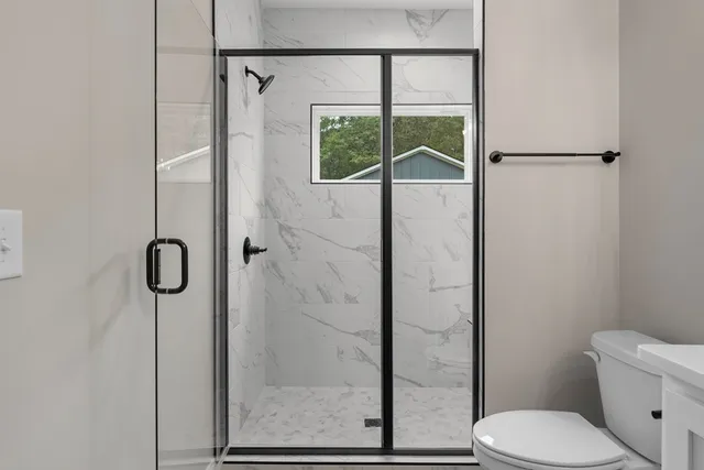 a bathroom with a toilet and a shower