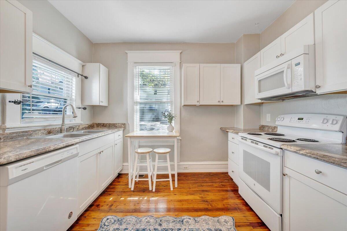 1008 5th Street Southeast Roanoke, VA 24013 - Photo 16 of 60 a kitchen with granite countertop a stove a sink and white cabinets