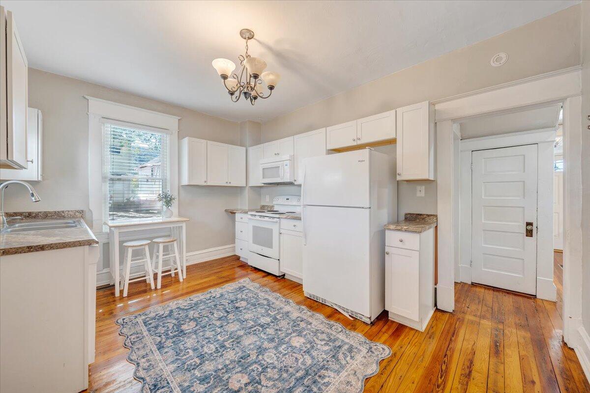 1008 5th Street Southeast Roanoke, VA 24013 - Photo 17 of 60 a kitchen with white cabinets and wooden floor