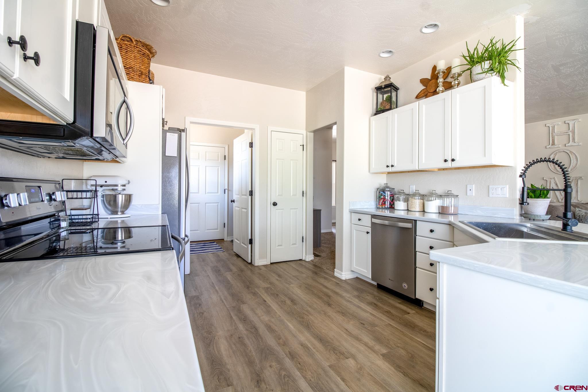42168 Rd J Mancos, CO 81328 - Photo 11 of 30 a kitchen with a refrigerator sink and white cabinets