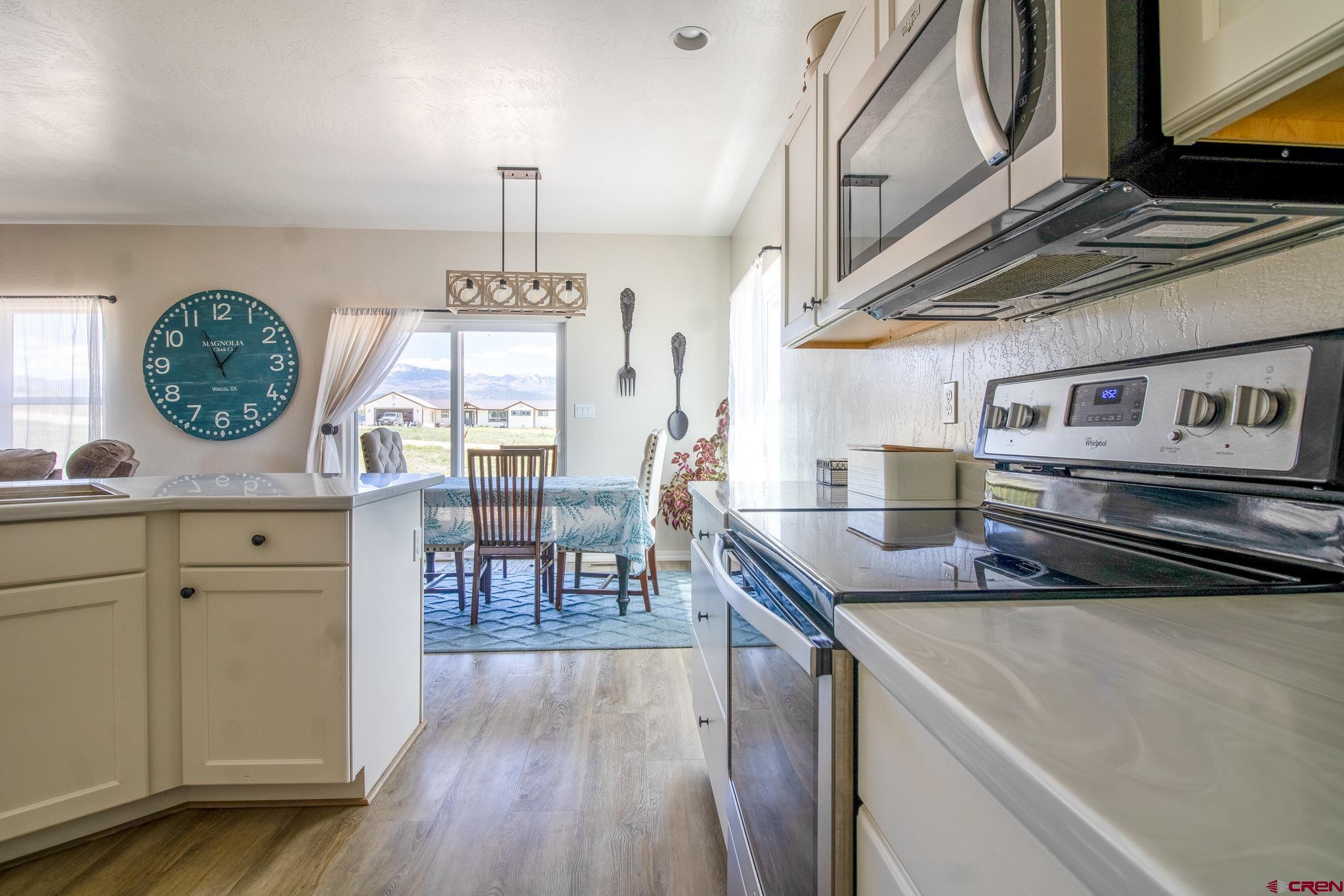 42168 Rd J Mancos, CO 81328 - Photo 9 of 30 a kitchen with stainless steel appliances granite countertop a stove a sink a dining table and chairs with wooden floor