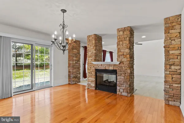 a view of a livingroom with wooden floor a fireplace and windows