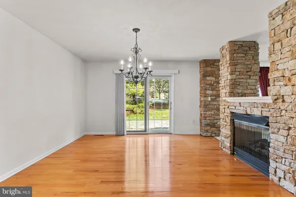 a view of empty room with wooden floor and fireplace