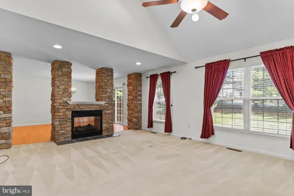 a view of empty room with fireplace and fan