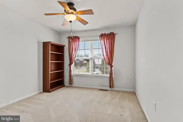 an empty room with closet and a chandelier fan