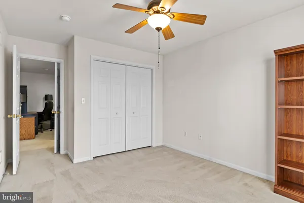 an empty room with windows and fan