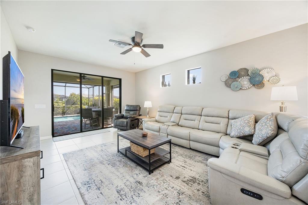 6125 Triumph Lane Ave Maria, FL 34142 - Photo 11 of 45 Living room featuring ceiling fan, healthy amount of natural light, and light tile patterned floors